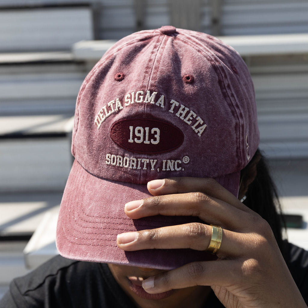 Person wearing a maroon Delta Sigma Theta cap with '1913 Sorority, Inc.' text.