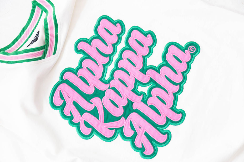 Alpha Kappa Alpha logo in pink and green on a white background