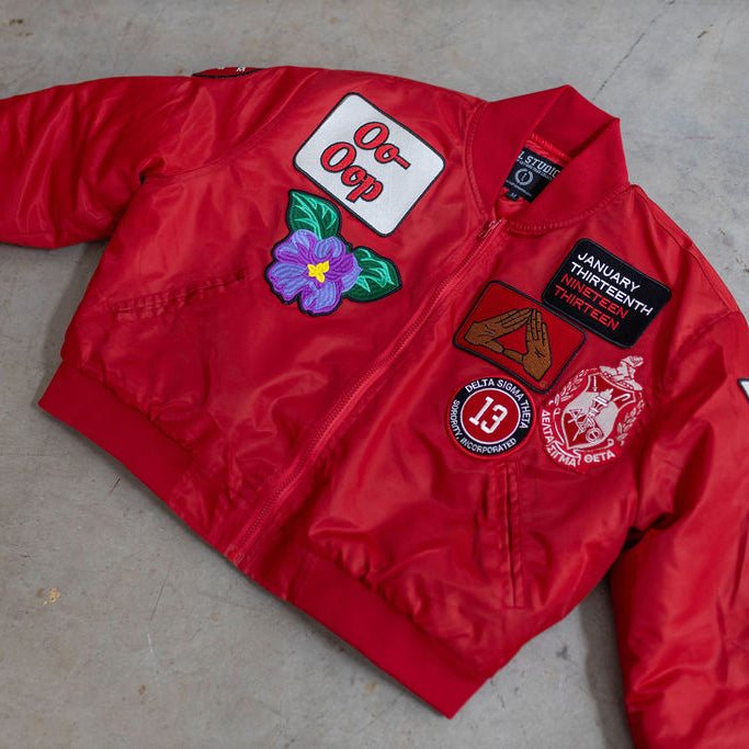 Red jacket with various patches on a concrete floor