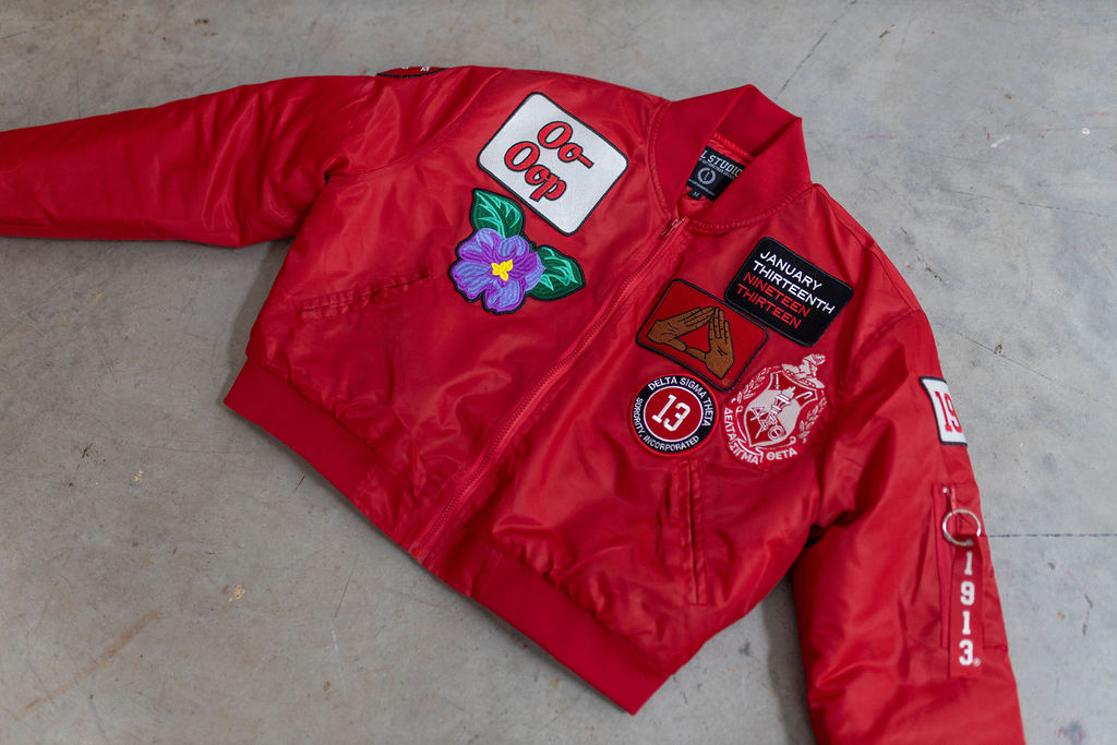 Red jacket with various patches on a concrete floor