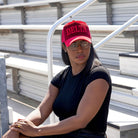 Person wearing a red 'DELTA' cap sitting on bleachers