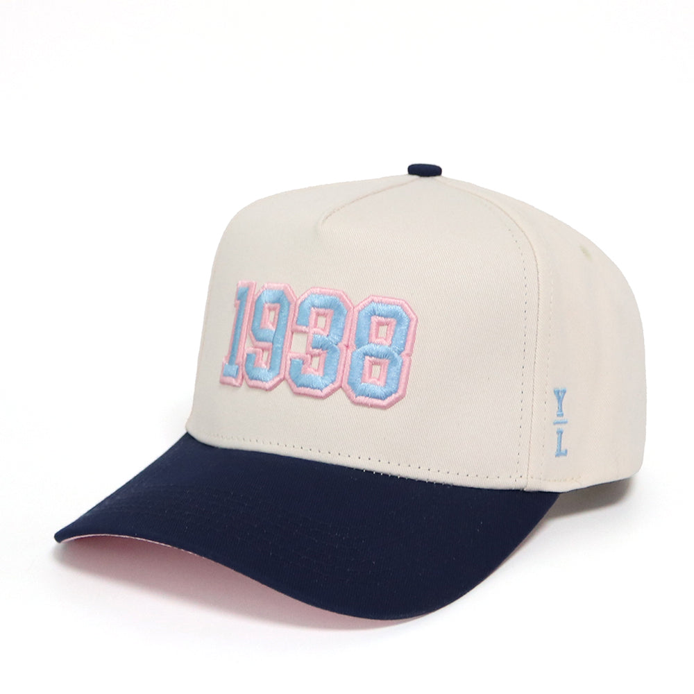 Beige and navy cap with '1938' embroidery on a white background